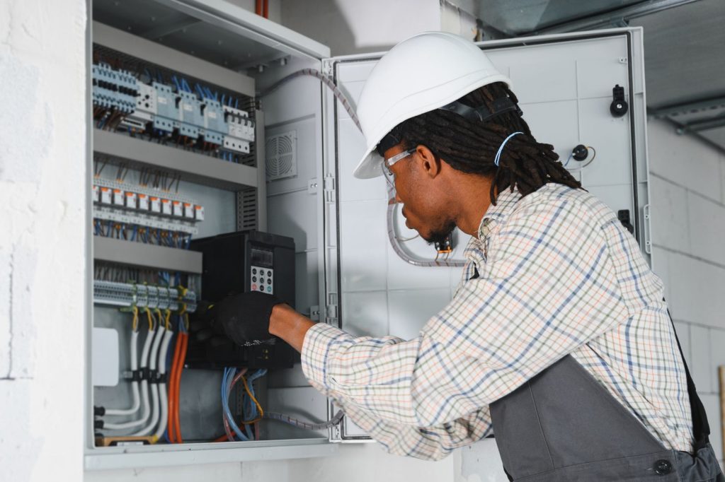 African american electrician installing ventilatiutc