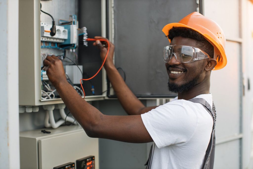 Repairman checking cables in power transformer atutc
