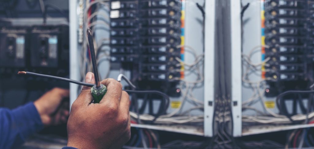Technician working on electrical circuit breaker putc
