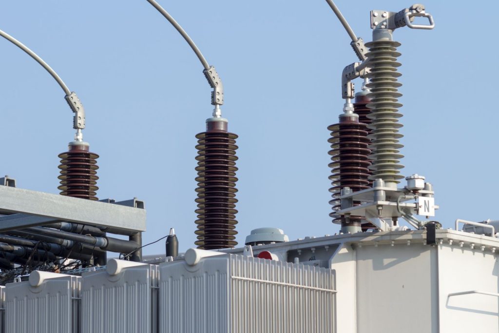 View of high voltage insulators on a clear blue skutc