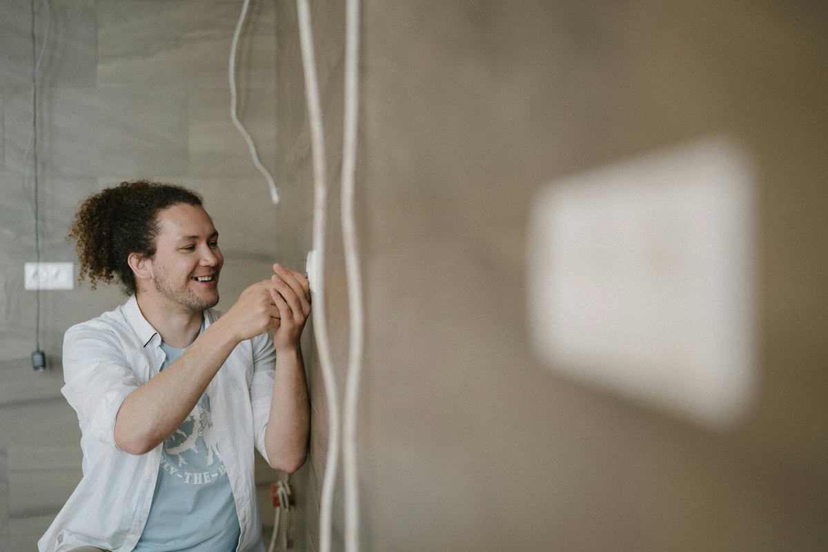 An electrician working on a wall outlet