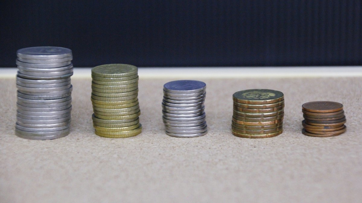 Coins stacked beside a calculator, representing savings