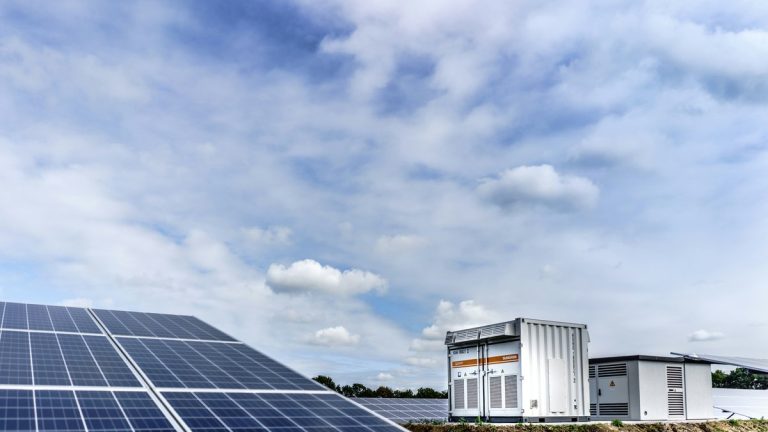 white and black solar panels under white clouds and blue sky during daytime