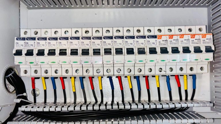 Close-up of an organized circuit breaker panel featuring color-coded electrical wiring.