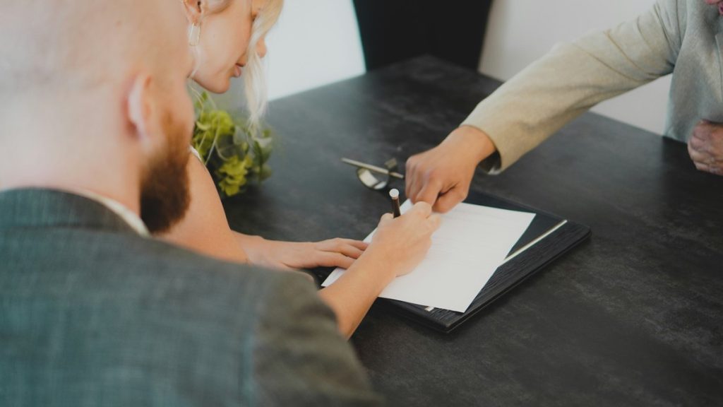 couple signing document at desk