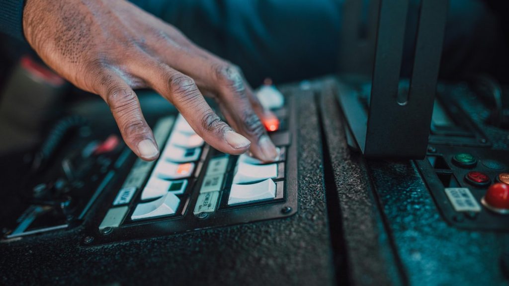 A close-up view of a hand manipulating switches on a control panel, showcasing technology interaction.