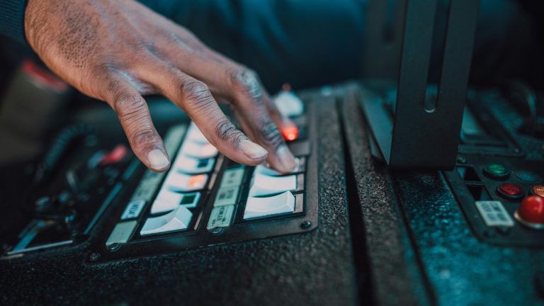 A close-up view of a hand manipulating switches on a control panel, showcasing technology interaction.