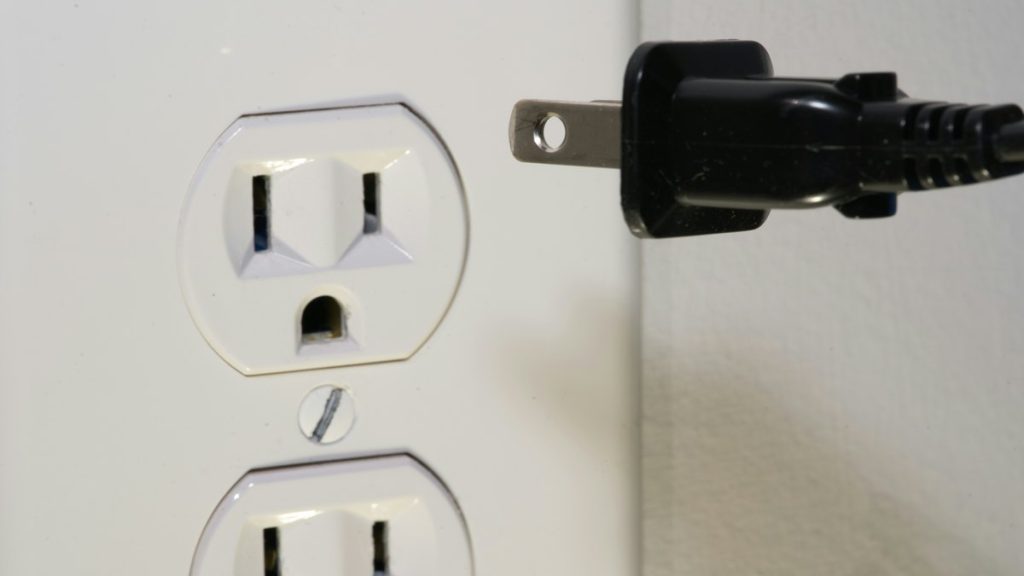 black male plug in front of electric socket