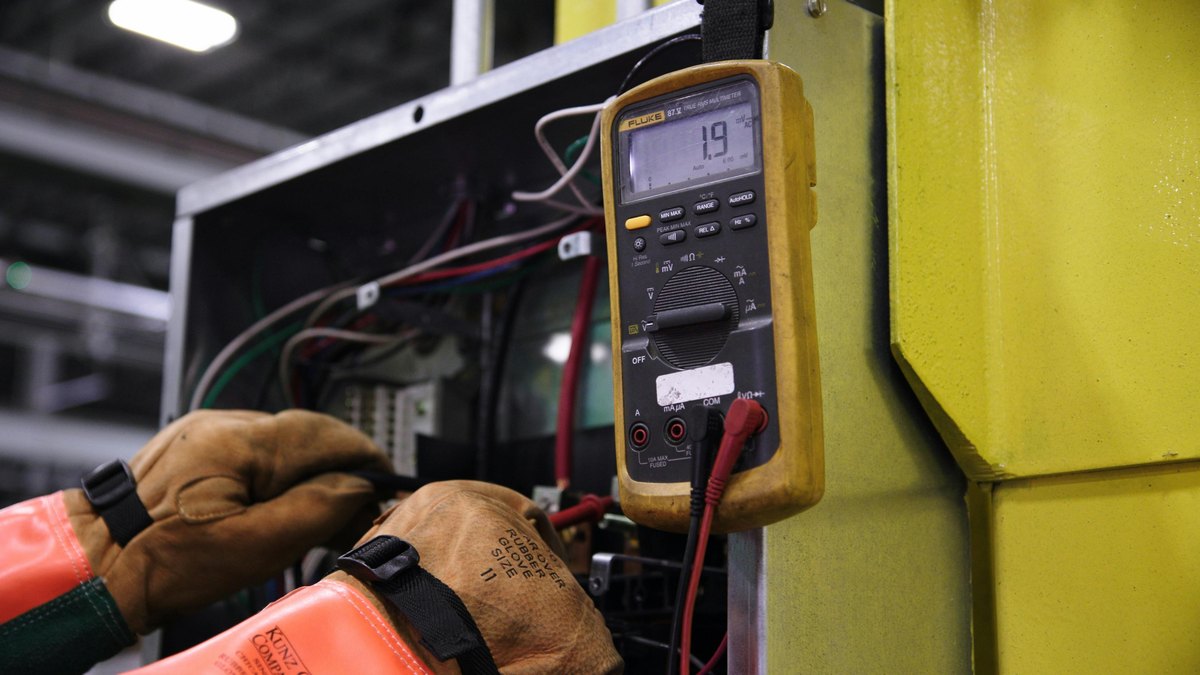 An electrician testing voltage with a multimeter