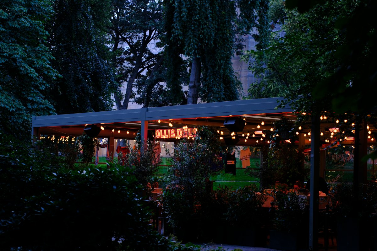 A patio lit with string lights in the evening