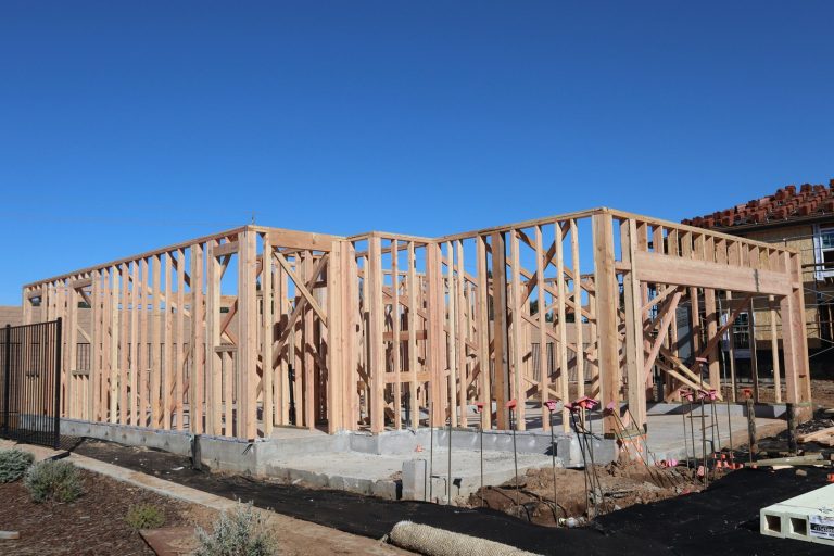 Wood framing of a house under construction in a sunny California subdivision.