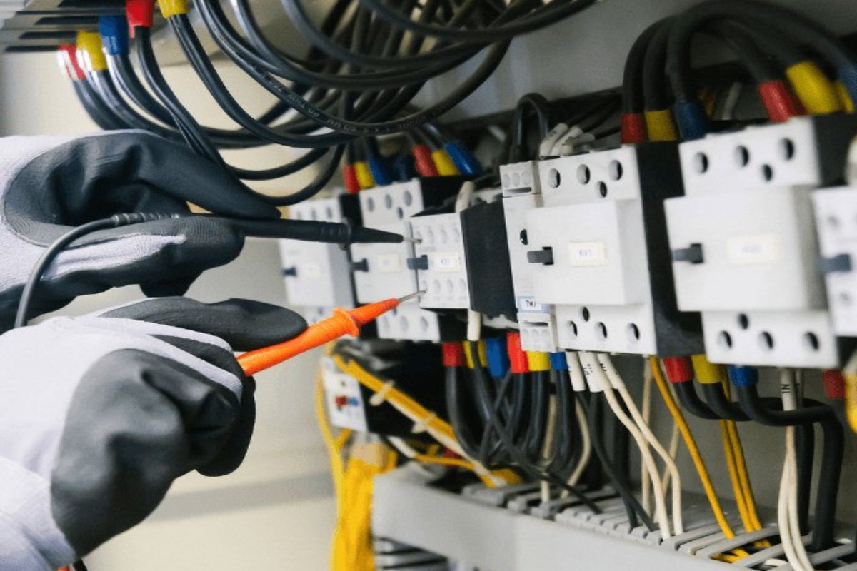 An electrician working at an electrical panel