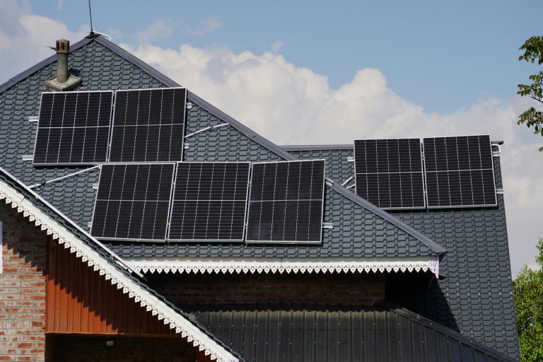 Rooftop solar panels on a house in Srinagar against a blue sky backdrop.