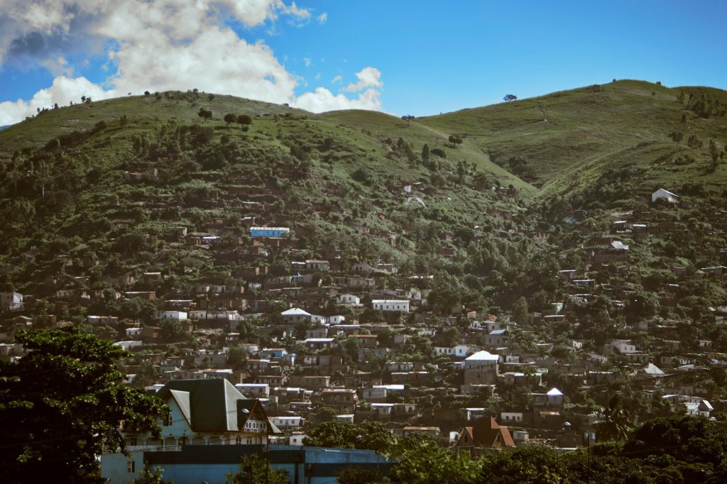 A picturesque hillside village with numerous houses, capturing lush greenery and clear skies.