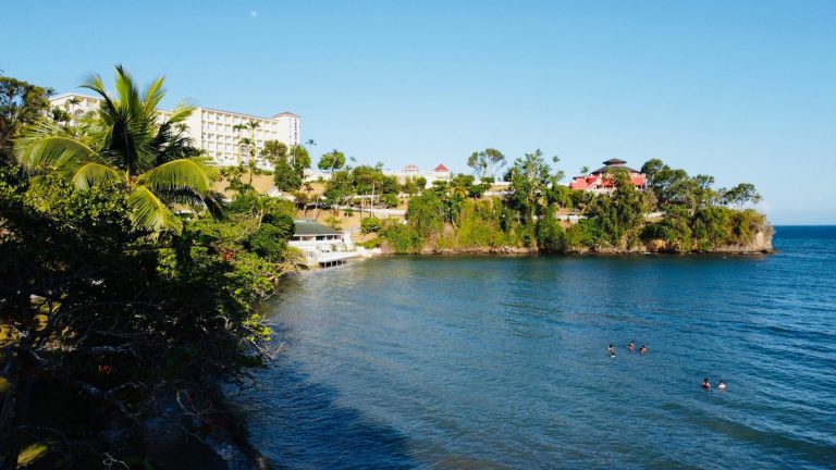 Serene bay with lush greenery and resort buildings, perfect for a relaxing vacation.