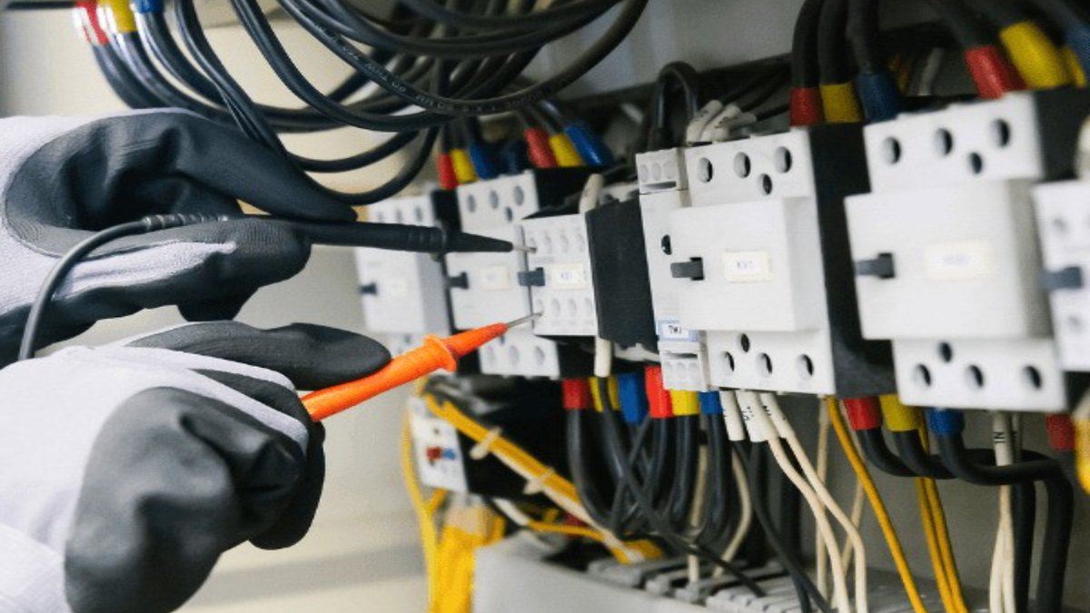 An electrician testing an electrical panel