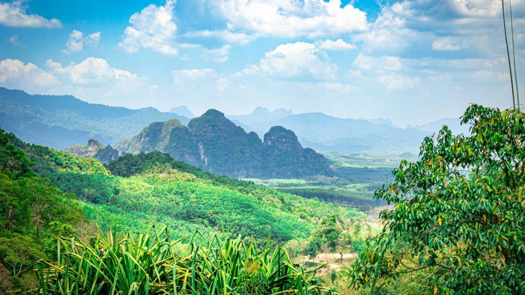 Lush green mountains under a cloudy blue sky