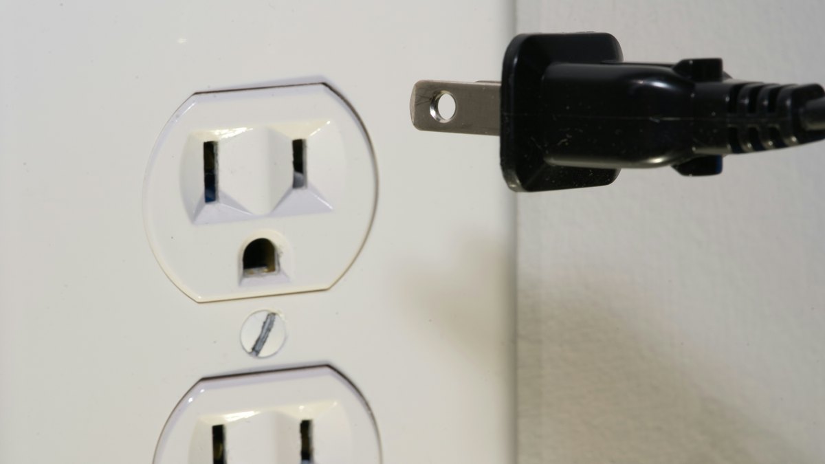 A plug in front of an electrical outlet