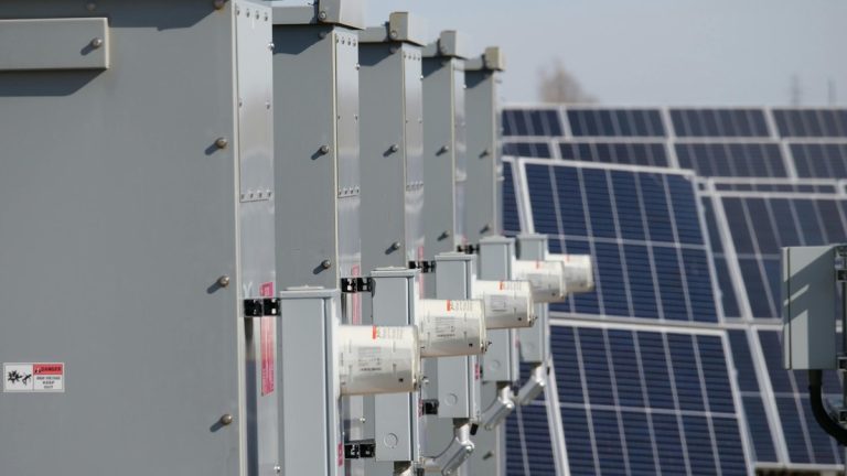 Close-up of electrical boxes and solar panels harnessing solar energy outdoors.
