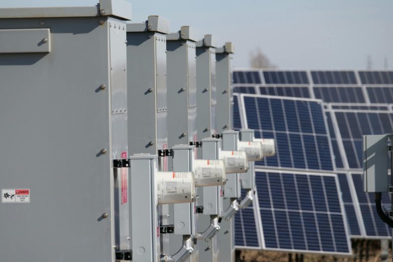 Close-up of electrical boxes and solar panels harnessing solar energy outdoors.